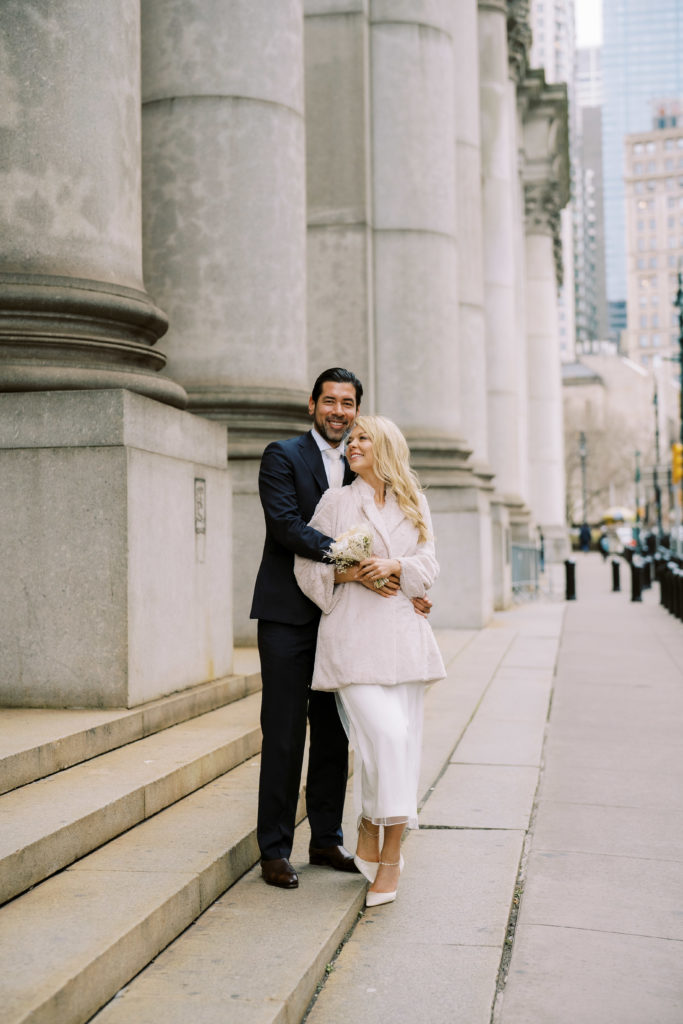 Bride and groom in front of the subway station in downtown Manhattan following their NYC City Hall Wedding