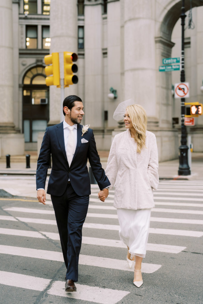 Bride and groom crossing Centre St. i downtown Manhattan after eloping at city hall. 