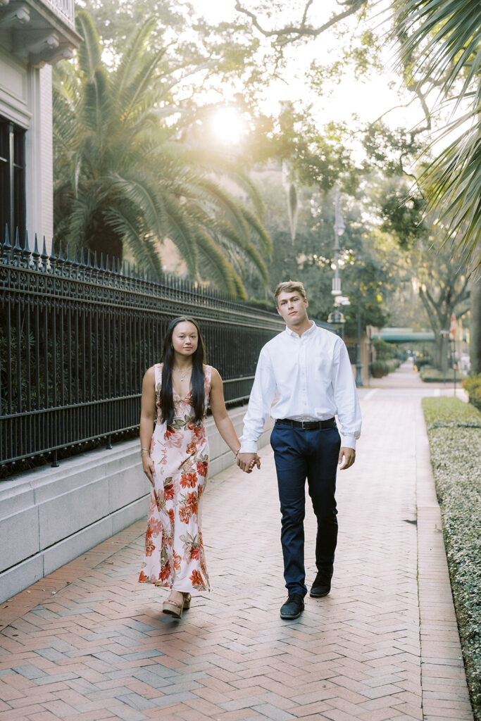 Couple walking through downtown Charleston, SC for their engagement photos.